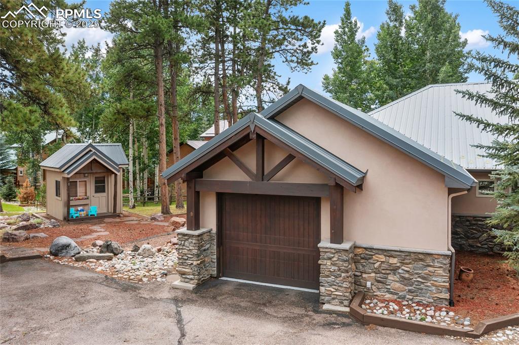 Image 7 of 46: Entrance to bonus side garage and a peekaboo view of the backyard playhouse