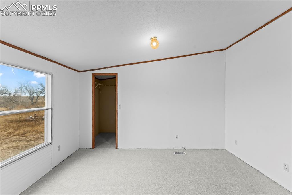 Image 11 of 32: Carpeted spare room featuring crown molding