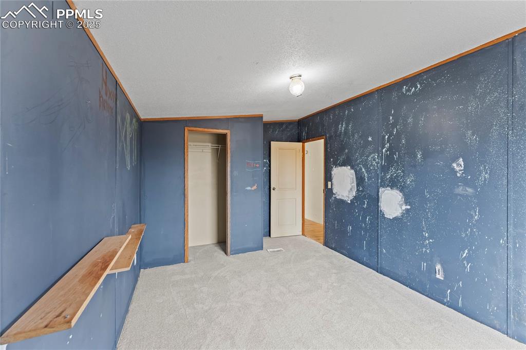 Image 14 of 32: Unfurnished bedroom featuring carpet flooring, a closet, and vaulted ceilin