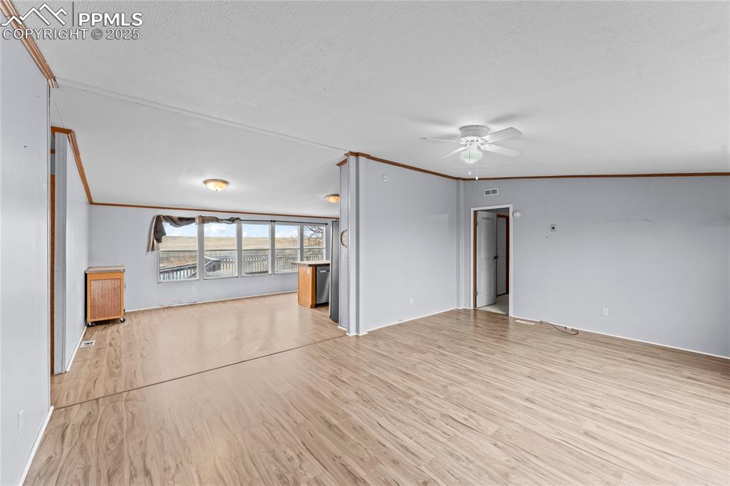Image 3 of 32: Unfurnished living room featuring crown molding, light wood-style flooring,