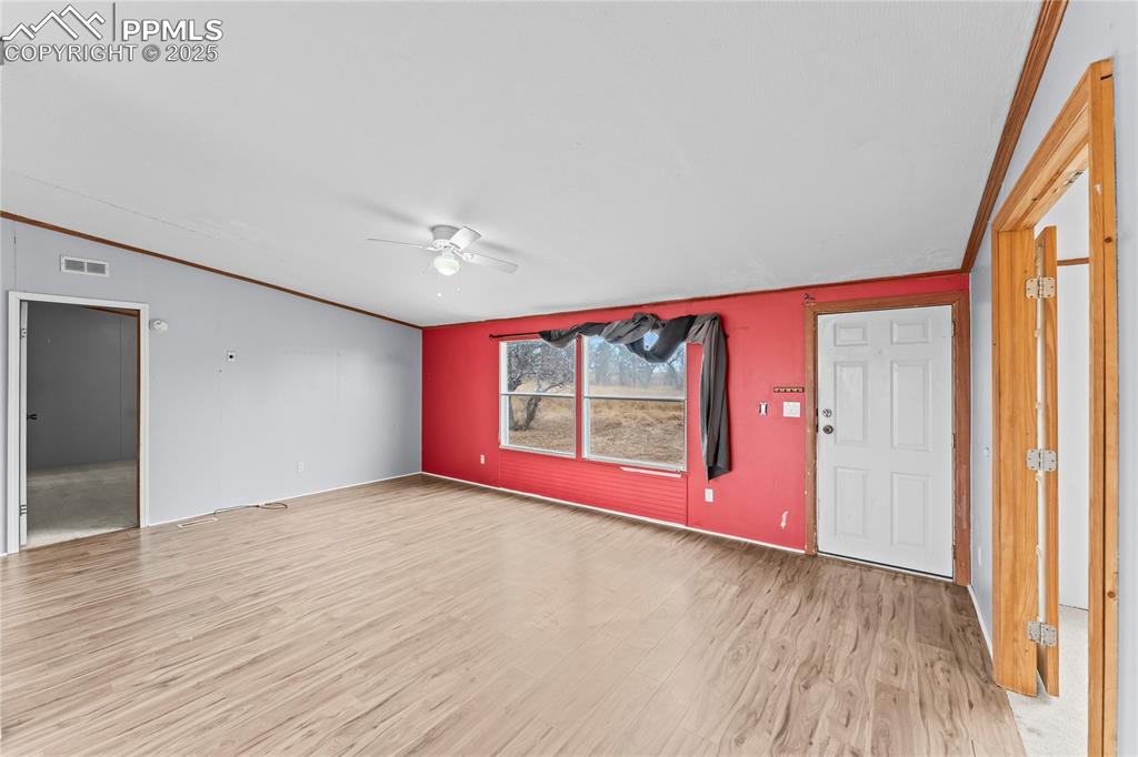 Image 4 of 32: Unfurnished living room with crown molding, light wood-style flooring, ceil