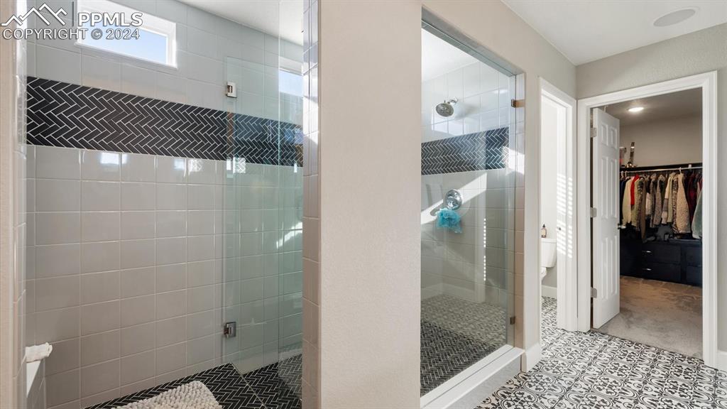Image 40 of 50: Upper Level Primary Bathroom with beautifully tiled shower.