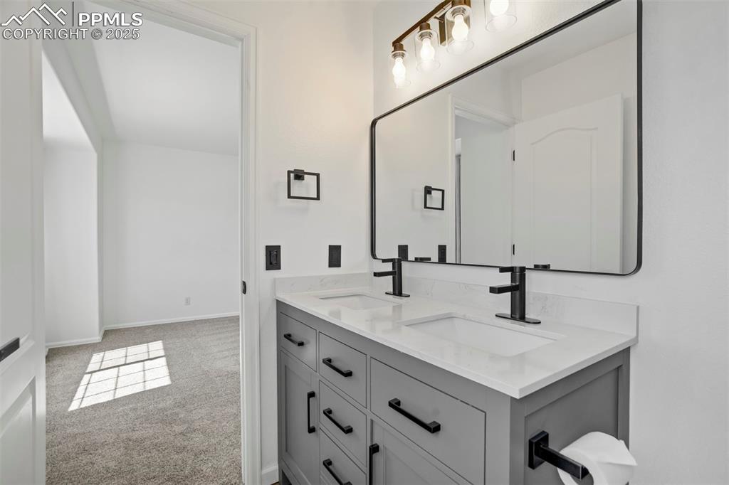 Image 26 of 48: Double sink with large mirror and sleek fixtures