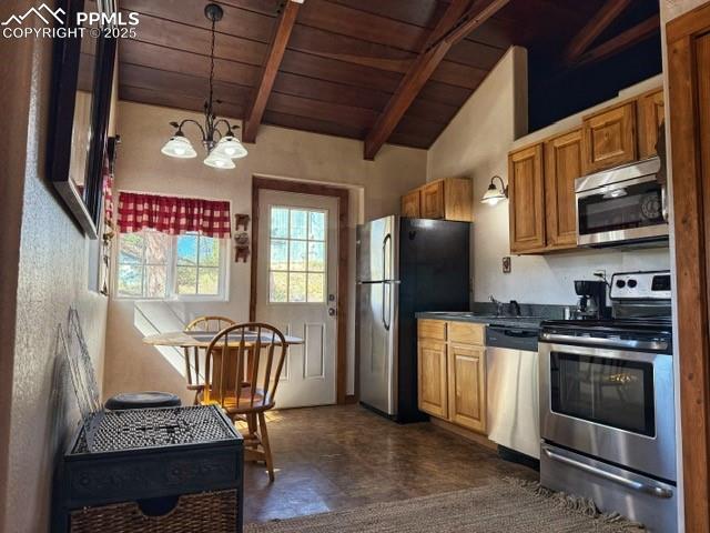 Image 4 of 15: Kitchen with stainless steel appliances, hanging light fixtures, brown cabi