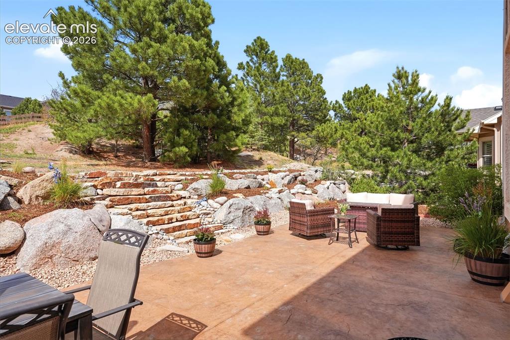 Image 3 of 47: Retaining wall and mature trees provide privacy and quiet