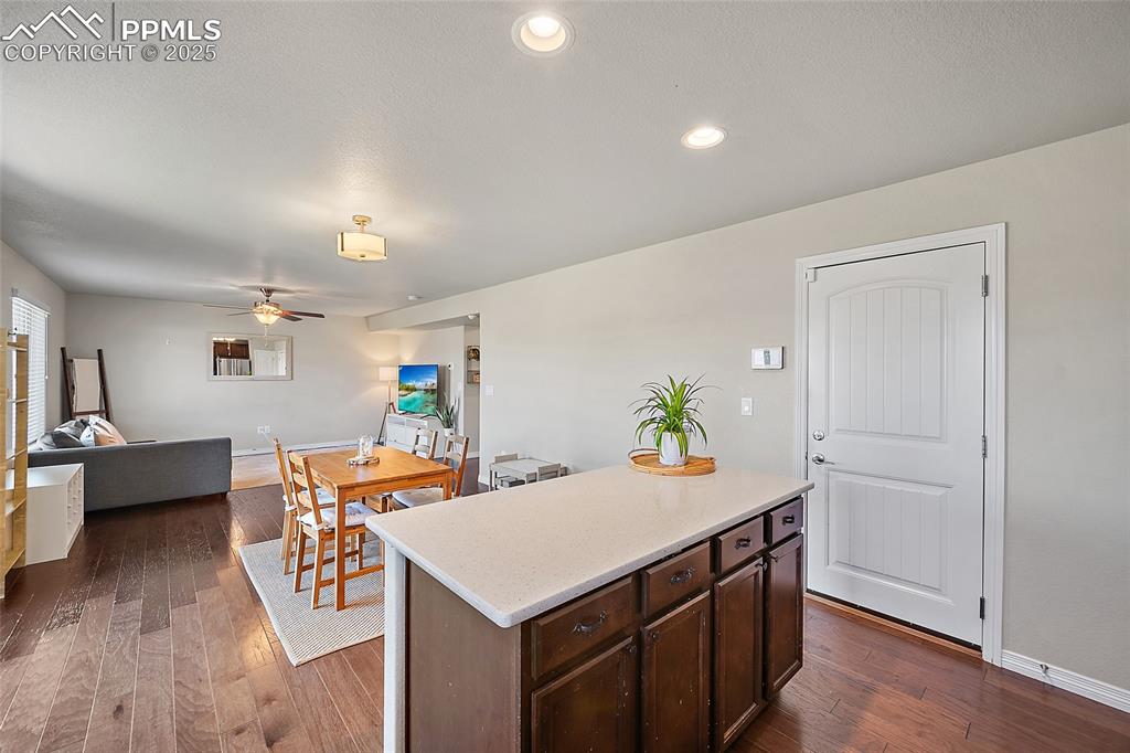 Image 13 of 38: Kitchen featuring dark brown cabinetry, a kitchen island, open floor plan, 