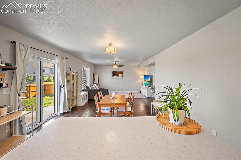 Image 14 of 38: Dining room featuring dark wood-style flooring, a textured ceiling, and a c
