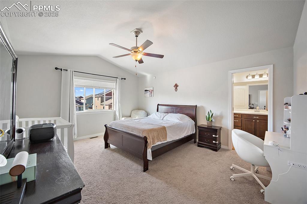 Image 18 of 38: Bedroom featuring an office area, light colored carpet, vaulted ceiling, ce