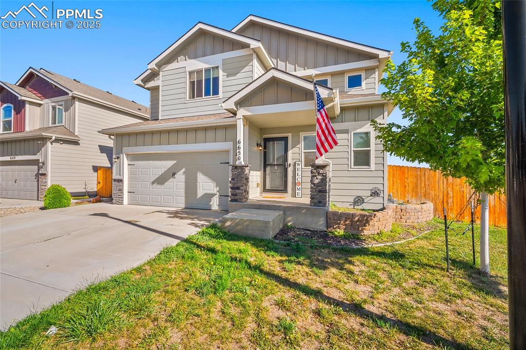 Image 2 of 38: Craftsman-style house with board and batten siding, an attached garage, con