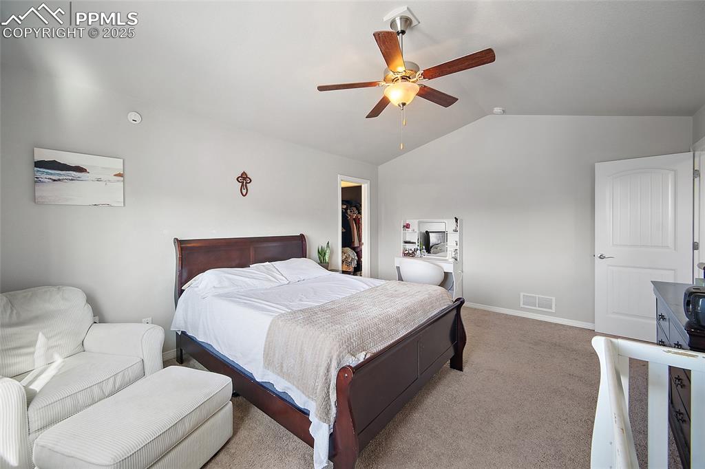 Image 20 of 38: Carpeted bedroom with lofted ceiling, a spacious closet, and a ceiling fan