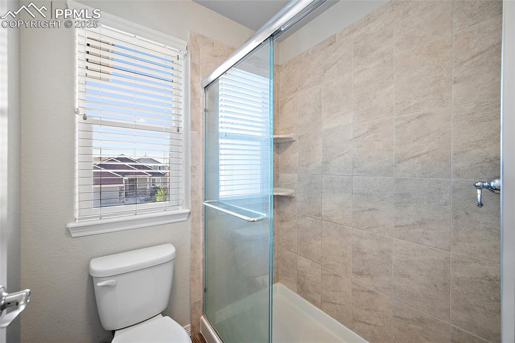 Image 22 of 38: Full bathroom with a stall shower and toilet