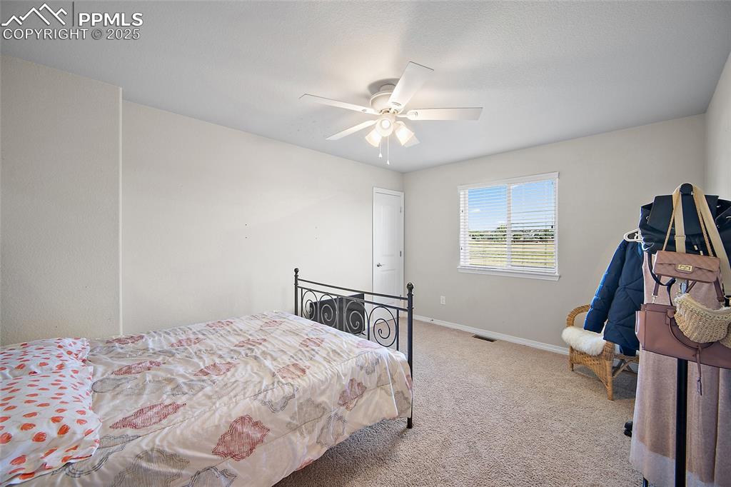 Image 24 of 38: Carpeted bedroom with baseboards and a ceiling fan