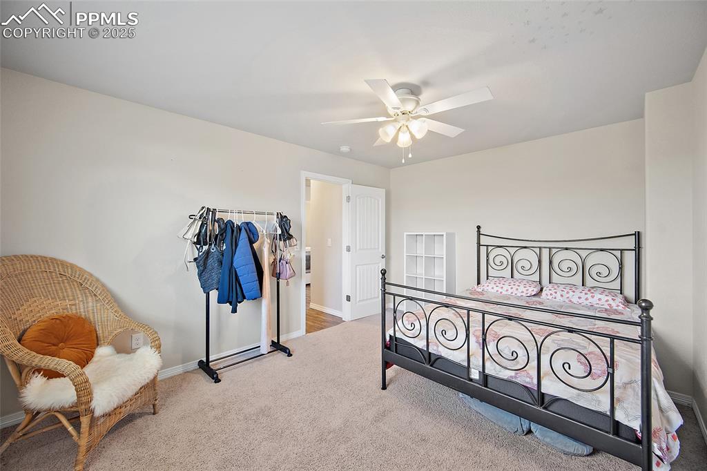Image 25 of 38: Carpeted bedroom with baseboards and ceiling fan