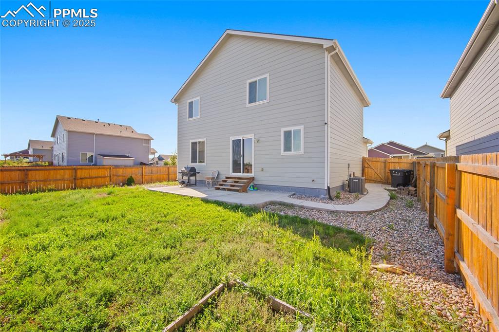 Image 30 of 38: Back of house featuring a patio area, a fenced backyard, and entry steps
