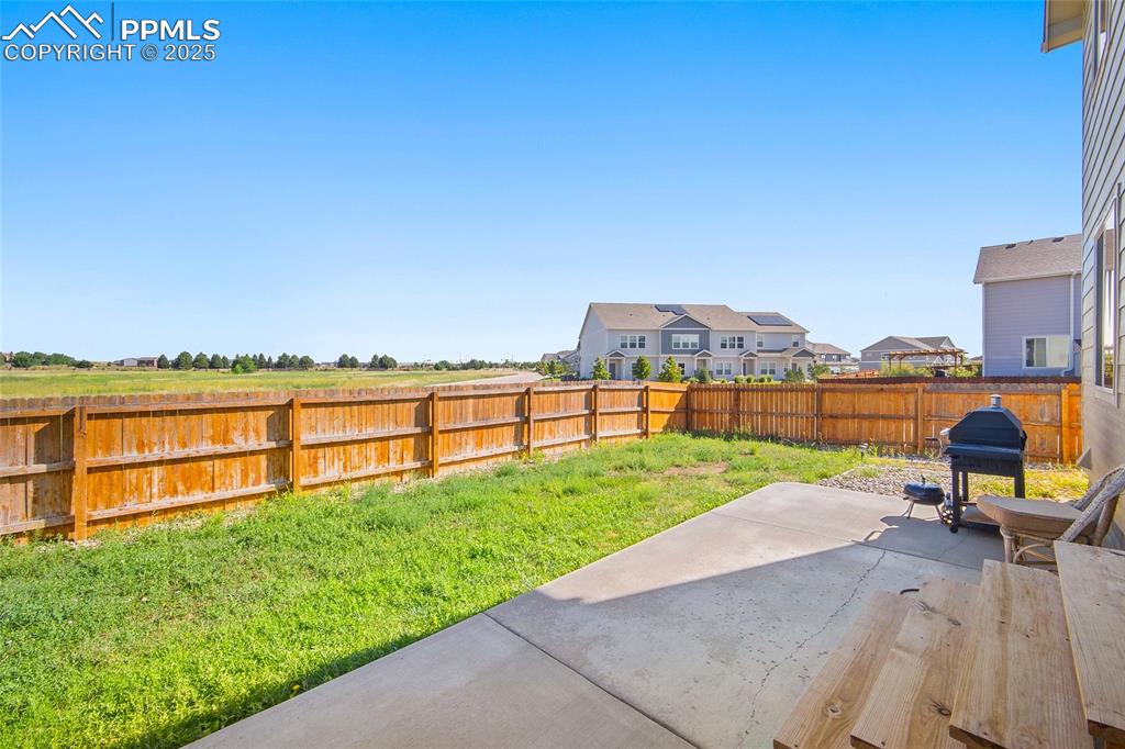 Image 32 of 38: Fenced backyard featuring a patio area and a residential view