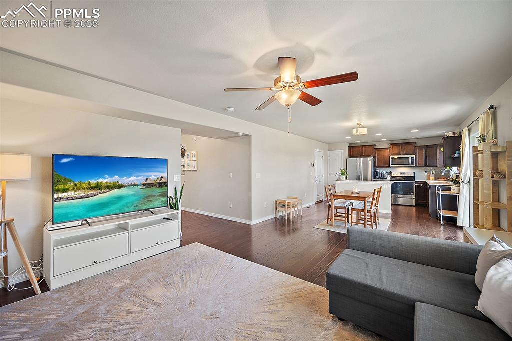 Image 9 of 38: Living room with dark wood-style floors, ceiling fan, and recessed lighting