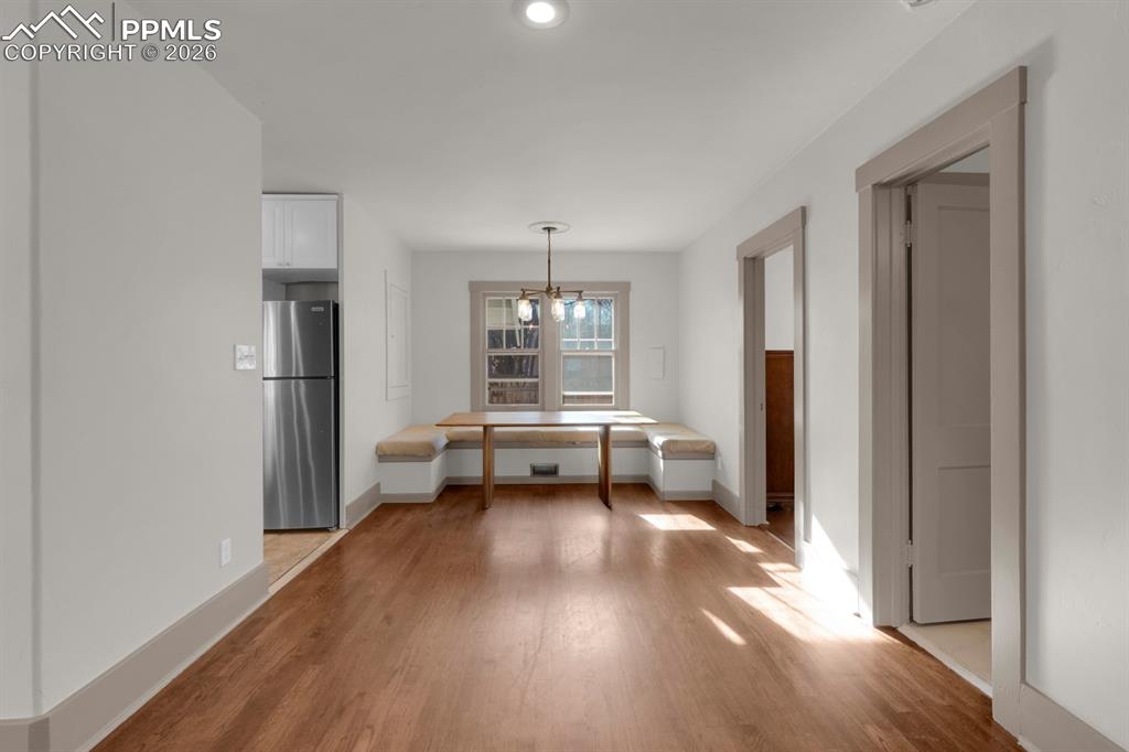 Image 12 of 39: Dining area with light wood-type flooring and a chandelier