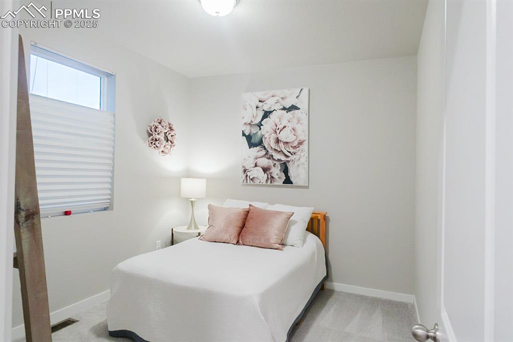 Image 13 of 37: This main-floor bedroom is spacious and has an adjacent 3/4 bath.