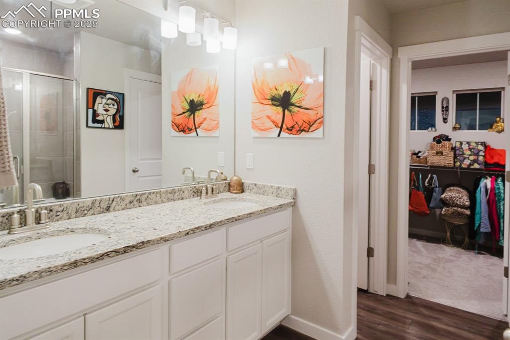 Image 21 of 37: The primary bathroom has dual vanities, a large shower, a private water clo