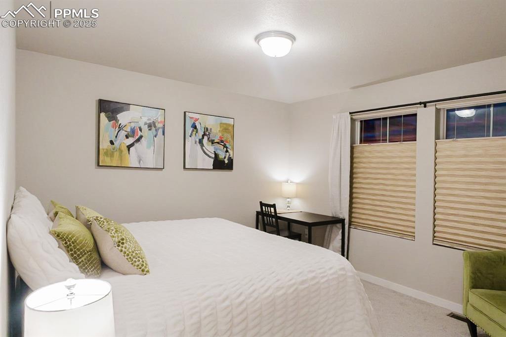 Image 26 of 37: The upstairs bedroom is spacious and bright, with two big windows.