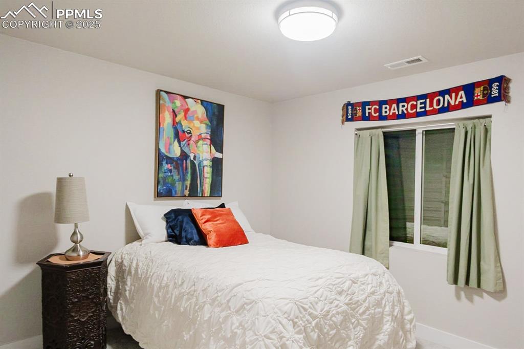 Image 33 of 37: The fifth bedroom is located on the basement level and has a large closet a