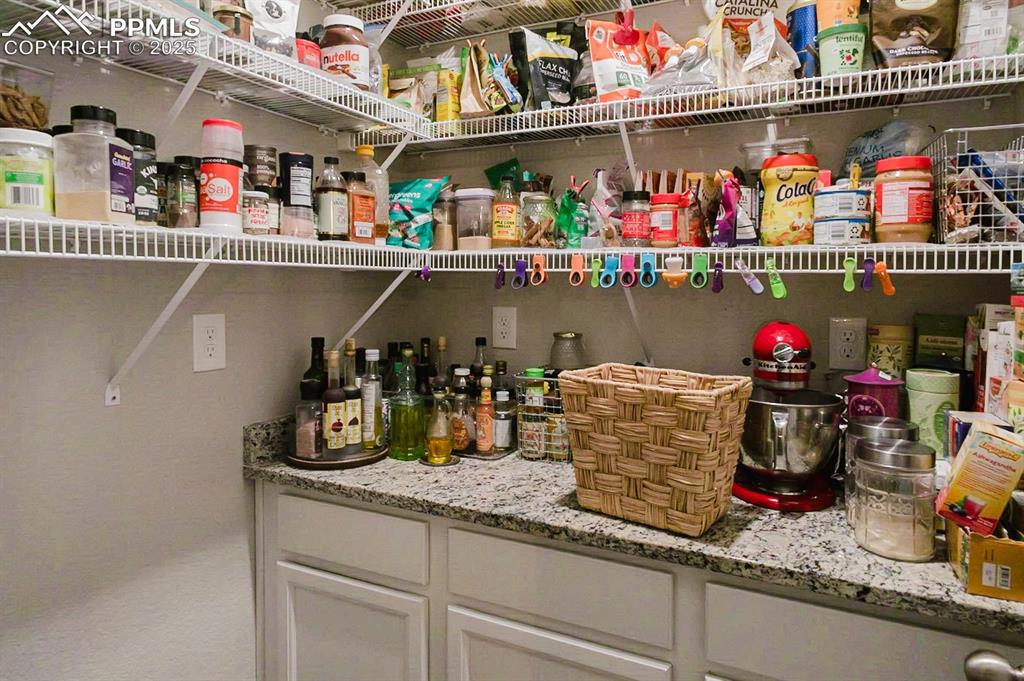 Image 9 of 37: The corner walk-in pantry has built-in cabinetry for additional storage.
