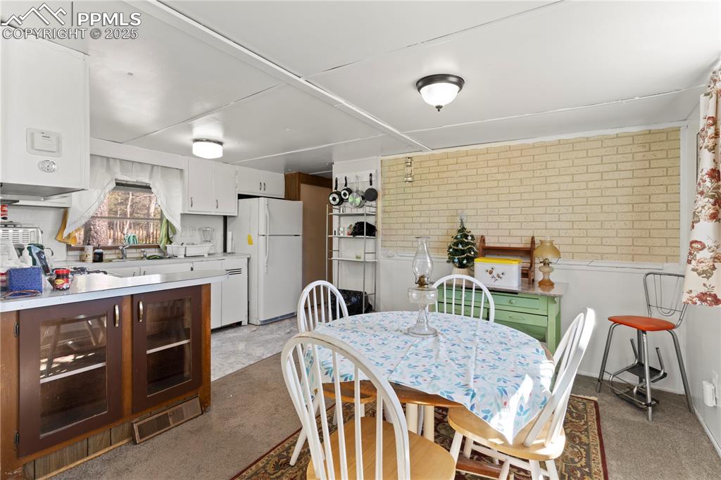 Image 12 of 31: Dining space featuring light colored carpet