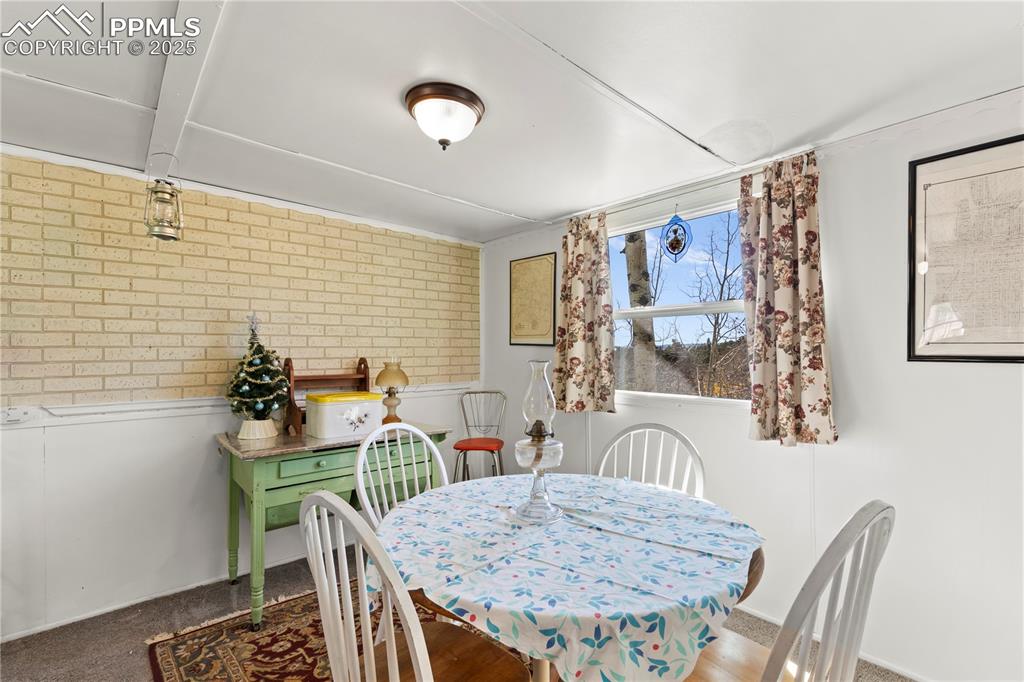 Image 13 of 31: Dining space with brick wall