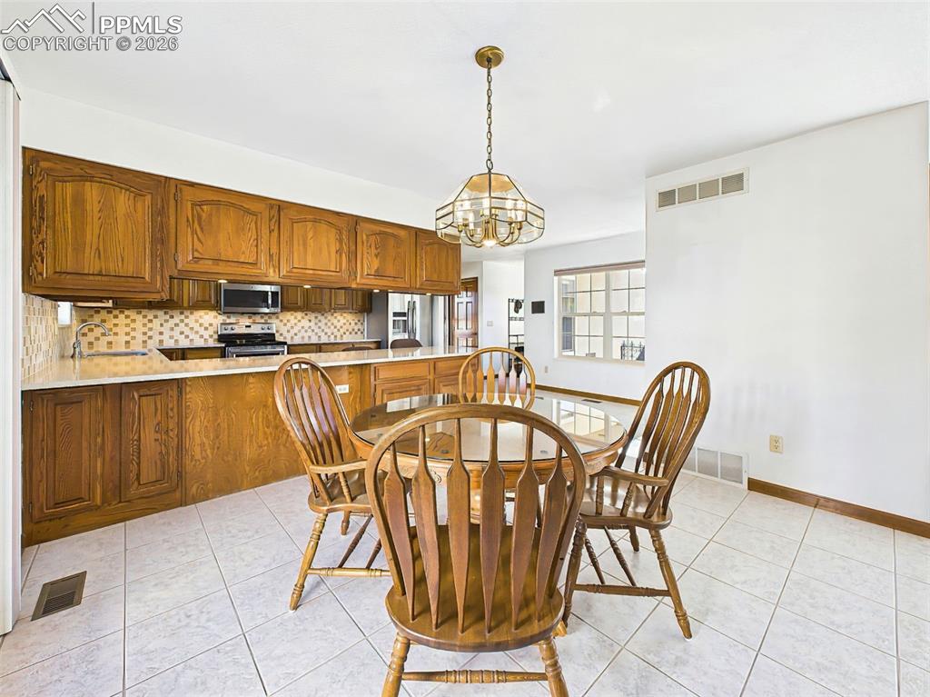 Image 11 of 50: Dining + Kitchen Combo – Tile flooring ties together the dining area and fu