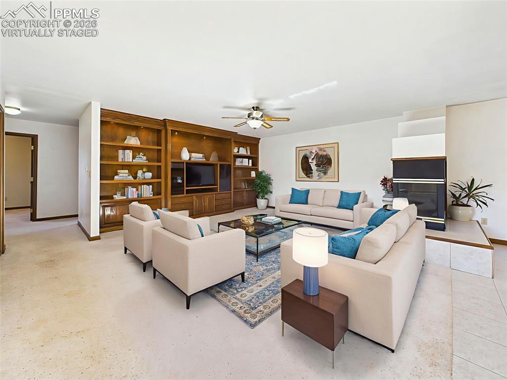Image 12 of 50: Virtually Staged – Spacious main living area with cozy dual-sided fireplace