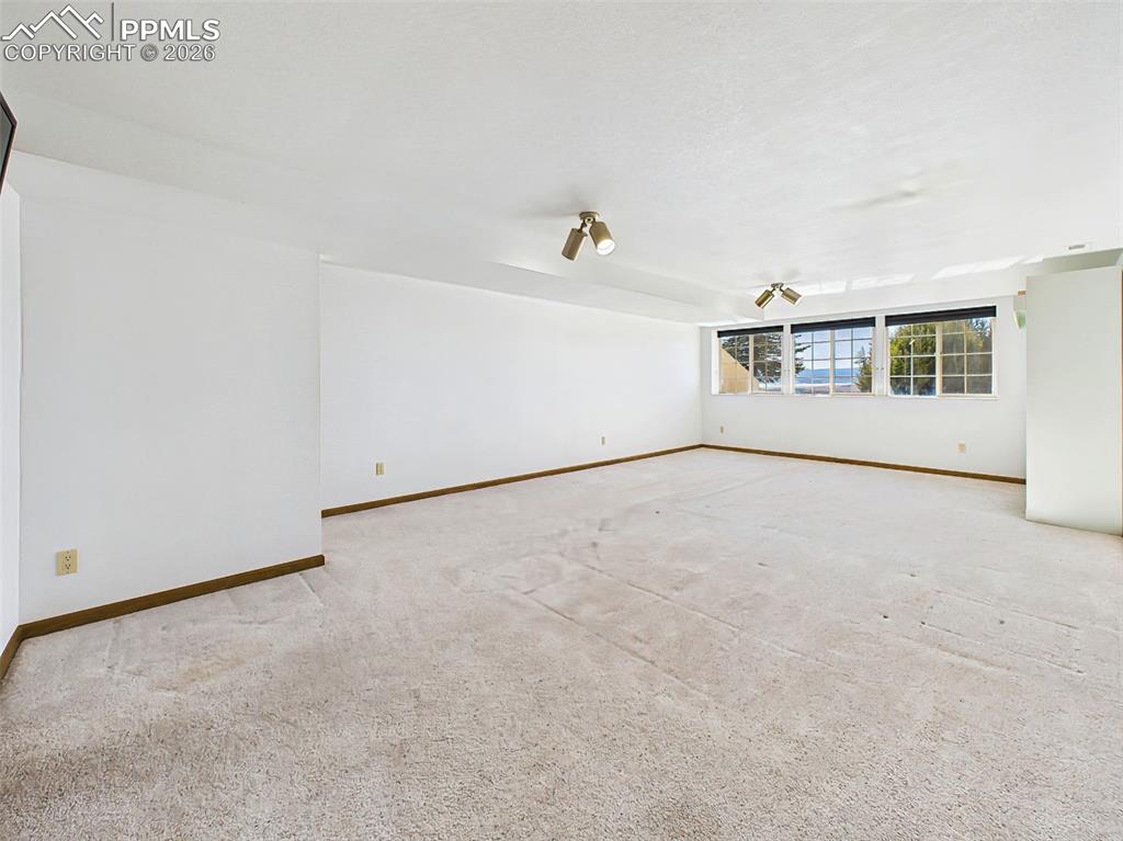 Image 31 of 50: Basement Family Room (Unstaged) – Large finished basement with open layout,