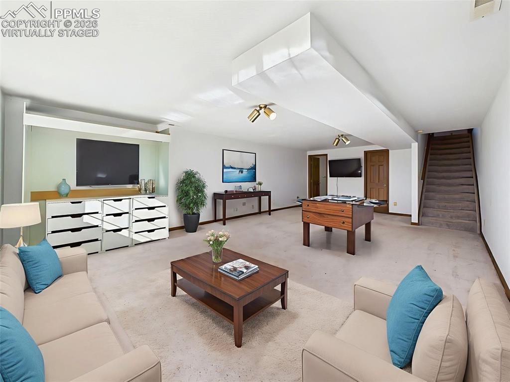 Image 32 of 50: Virtually Staged – Bright basement lounge area with wall-to-wall windows an