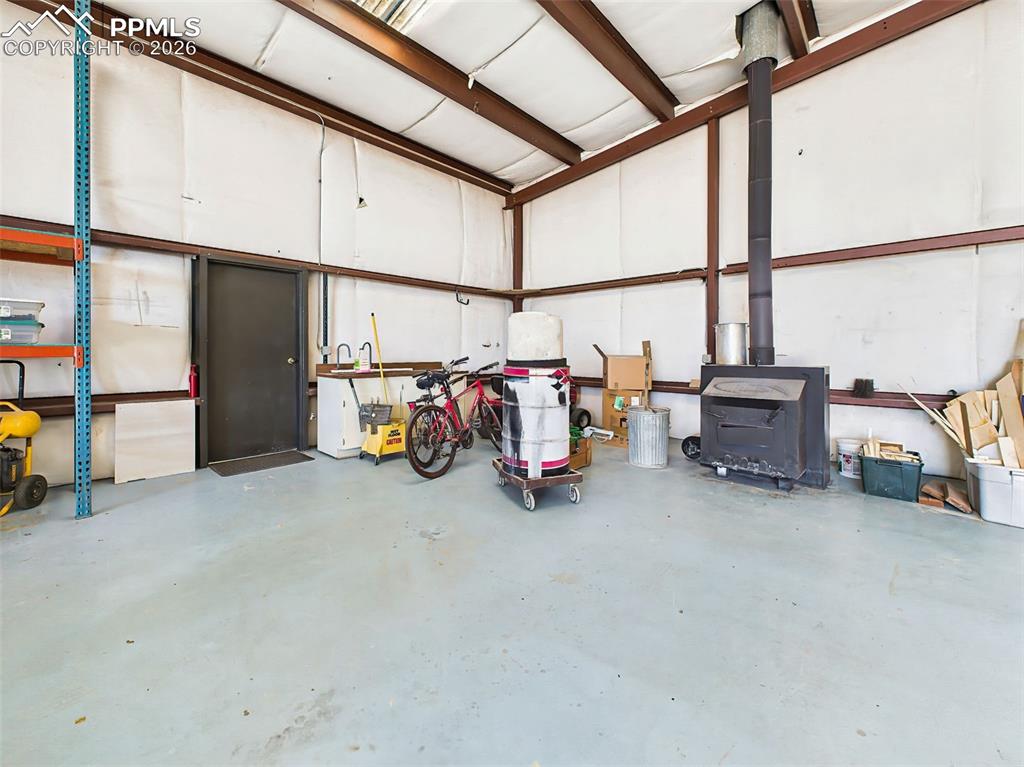 Image 43 of 50: Shop Corner with Wood Stove – Insulated workspace with wood-burning stove,