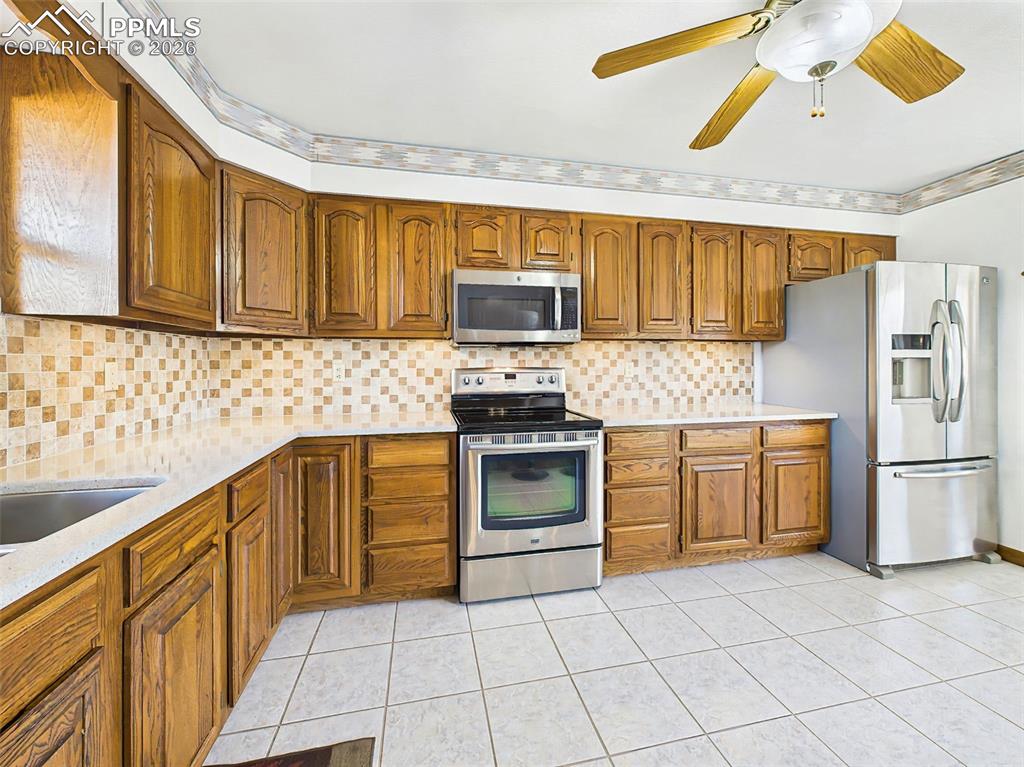 Image 7 of 50: Kitchen – Oven Wall – Extensive wood cabinetry and stainless steel applianc