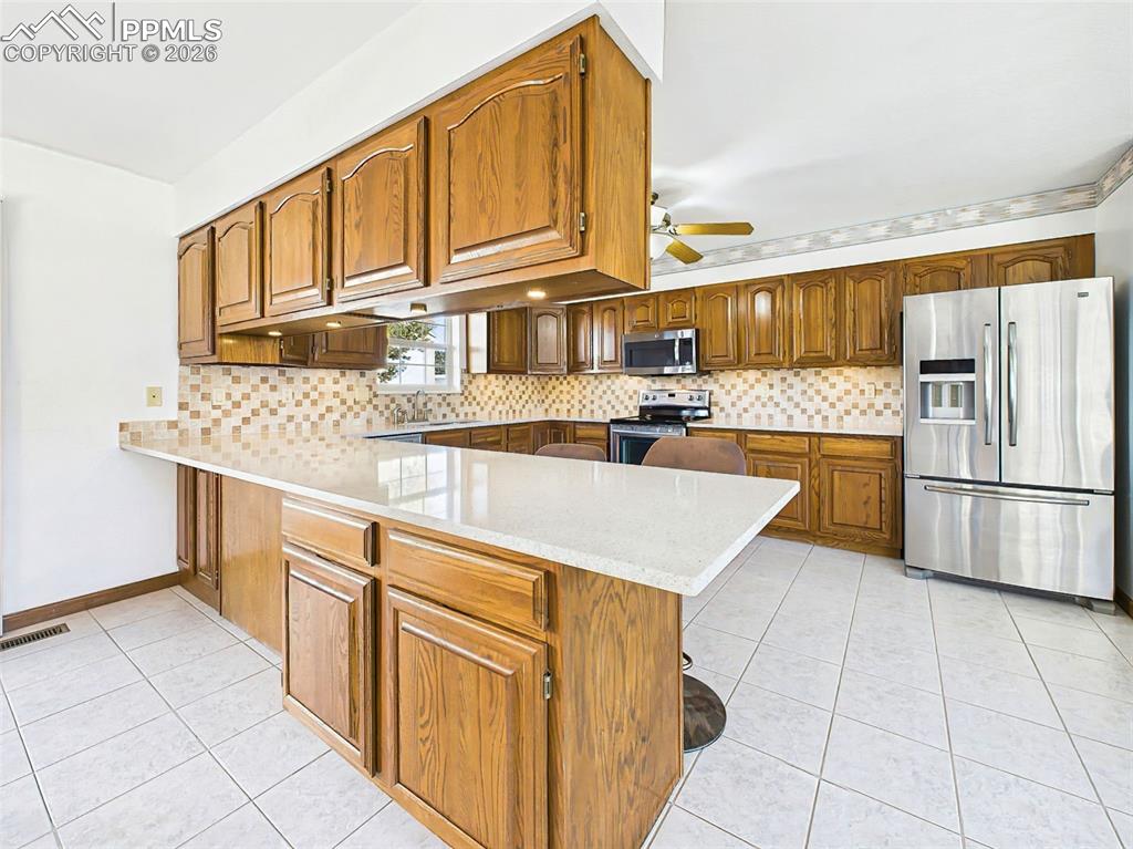 Image 8 of 50: Breakfast Bar – Alt View – Elevated bar seating flows into the kitchen, wit