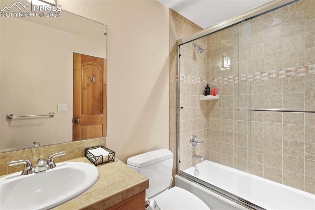 Image 15 of 19: Full lower level Bathroom with vanity and enclosed tub / shower combo