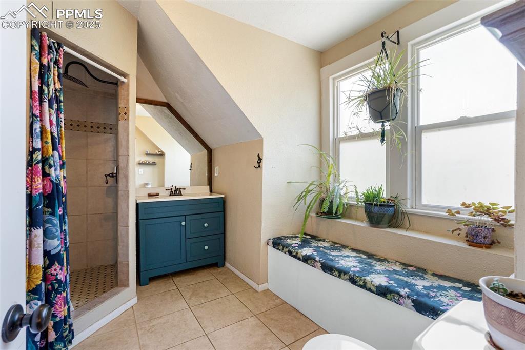 Image 22 of 49: Full bathroom featuring vanity, light tile patterned floors, and a stall sh