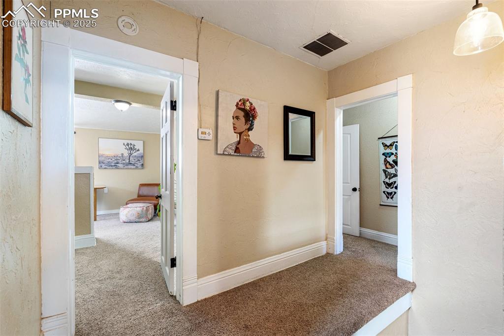 Image 25 of 49: Hall with a textured wall and carpet floors