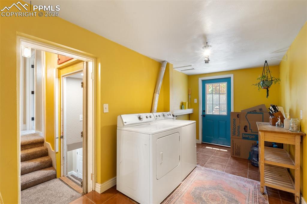 Image 40 of 49: Washroom with light tile patterned floors and independent washer and dryer