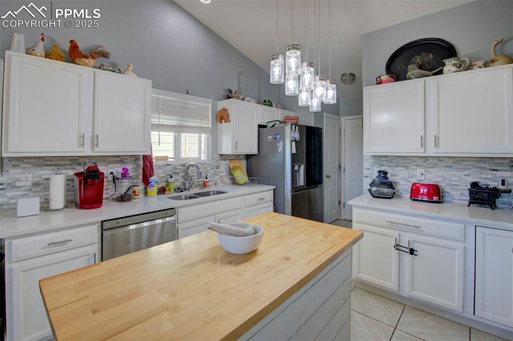 Image 12 of 44: Kitchen featuring appliances with stainless steel finishes, white cabinetry