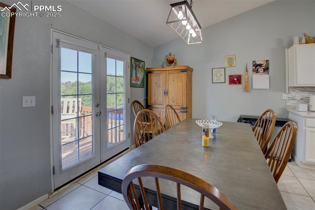 Image 14 of 44: Dining area featuring light tile patterned floors, french doors, and vaulte
