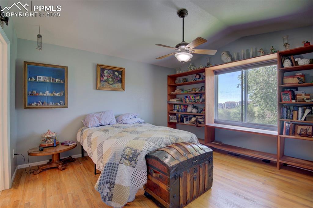 Image 15 of 44: Bedroom with wood finished floors, lofted ceiling, and a ceiling fan