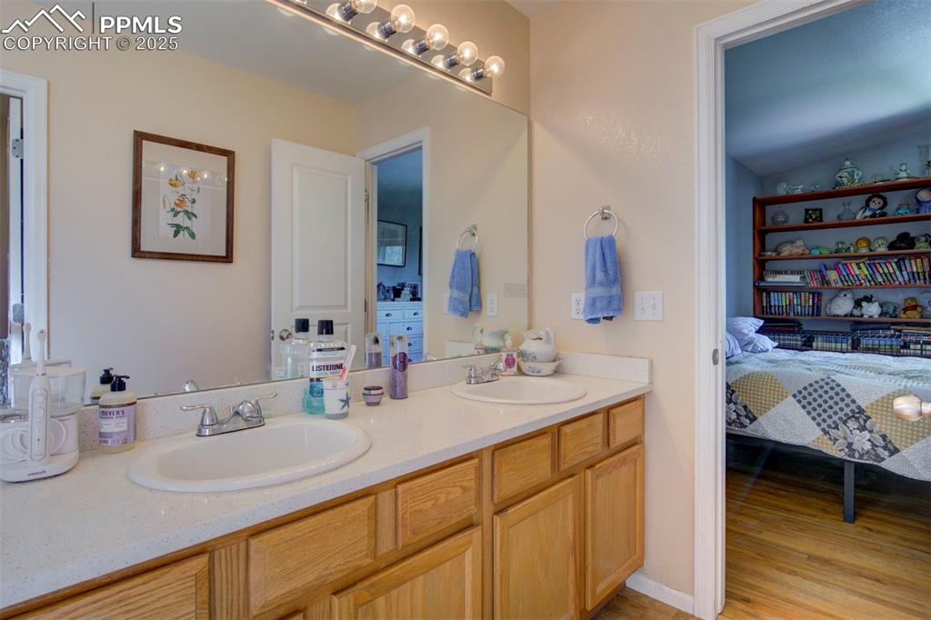 Image 17 of 44: Ensuite bathroom with double vanity and wood finished floors