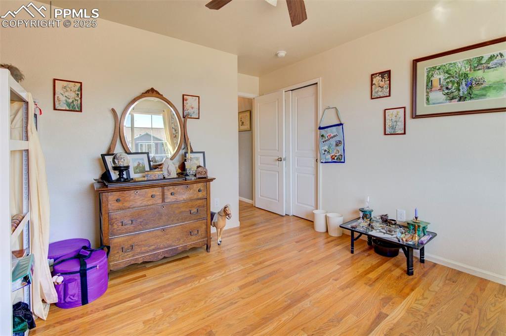 Image 23 of 44: Sitting room with light wood finished floors and ceiling fan