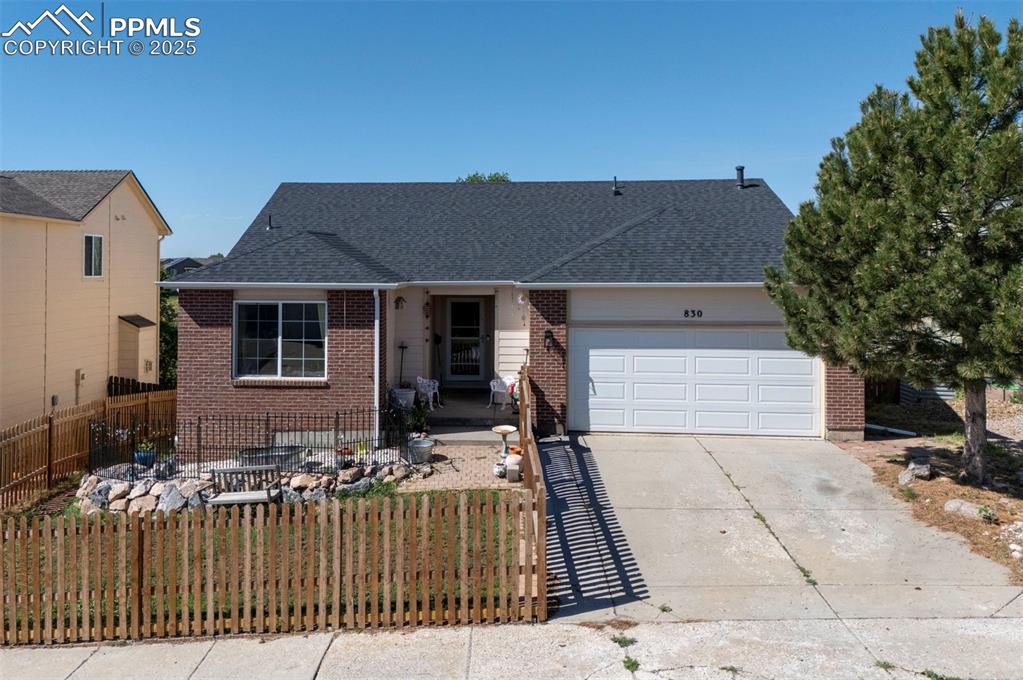 Image 3 of 44: View of front of home featuring brick siding, a garage, concrete driveway, 
