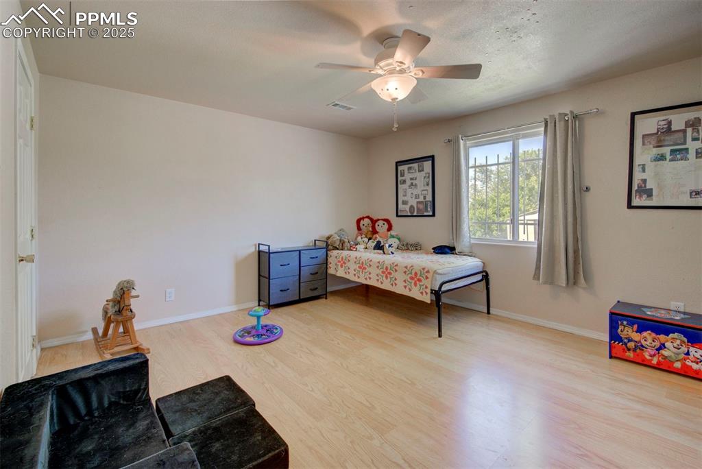 Image 31 of 44: Bedroom with wood finished floors and a ceiling fan