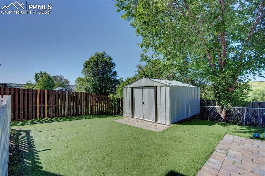 Image 40 of 44: Fenced backyard featuring a storage shed