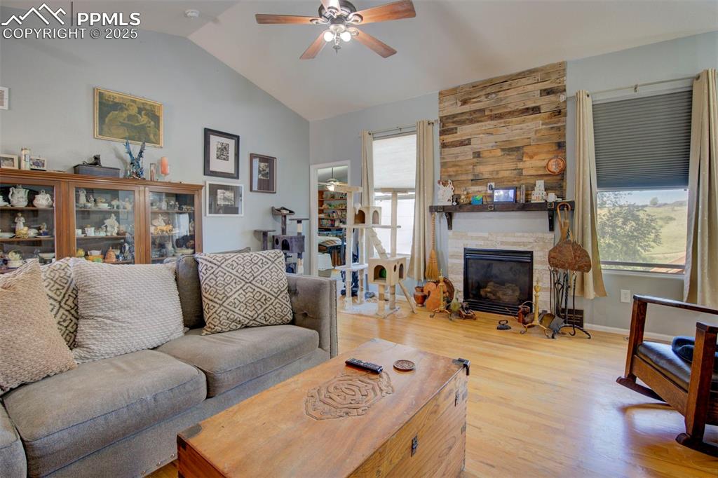 Image 5 of 44: Living area with a ceiling fan, wood finished floors, vaulted ceiling, and 