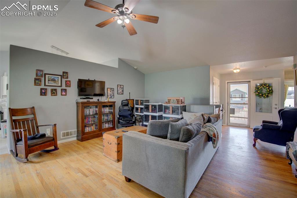Image 6 of 44: Living room with lofted ceiling, light wood finished floors, and a ceiling 
