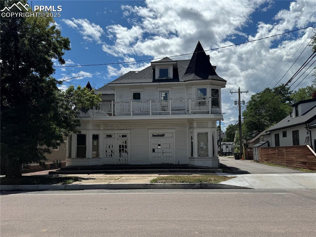 Caption: Victorian-style house with a balcony and roof with shingles
